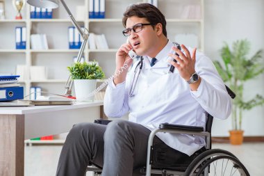Hastanede çalışan tekerlekli sandalyedeki engelli doktor.