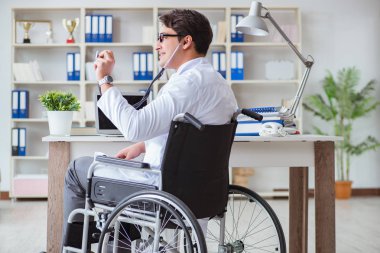 Hastanede çalışan tekerlekli sandalyedeki engelli doktor.