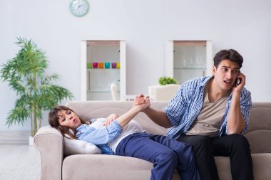 Evde kocası olan hamile bir kadın.