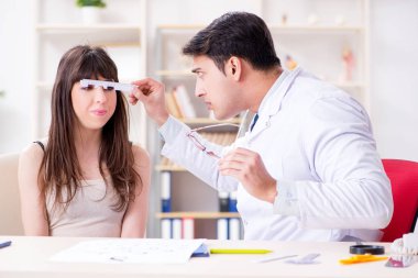 Oftalmolog göz doktoru hastanesindeki hastaları kontrol ediyor.