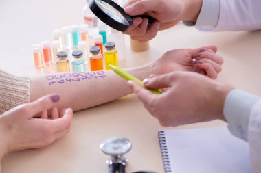 Hastanedeki hastanın alerji reaksiyonunu test eden doktor.