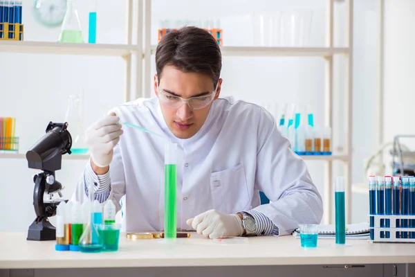 Jovem estudante de química que trabalha em laboratório em produtos químicos — Fotografia de Stock