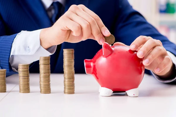 Businessman with stacks of coins in the office — Stock Photo, Image