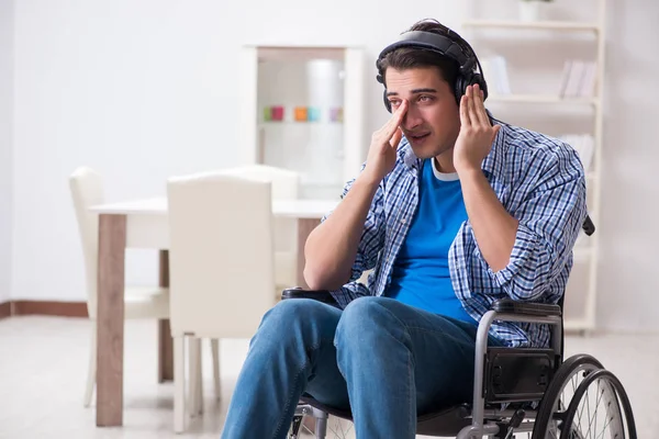 Инвалид слушает музыку в инвалидном кресле — стоковое фото