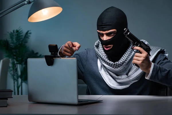 Ladrão terrorista com arma a trabalhar no computador — Fotografia de Stock