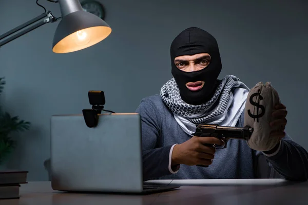 Ladrón terrorista con pistola trabajando en la computadora —  Fotos de Stock