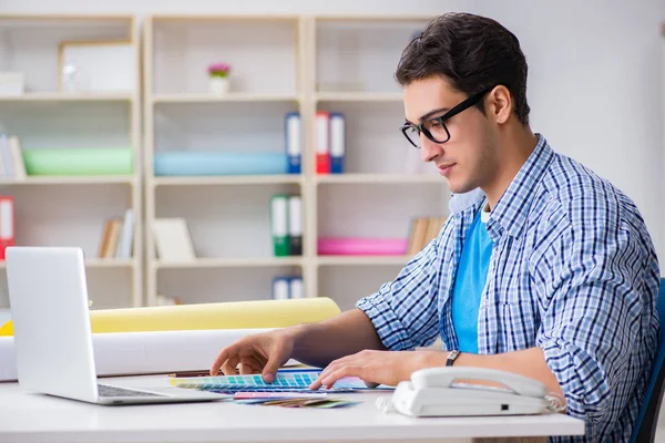 Joven diseñador trabajando en un nuevo proyecto y eligiendo colores —  Fotos de Stock