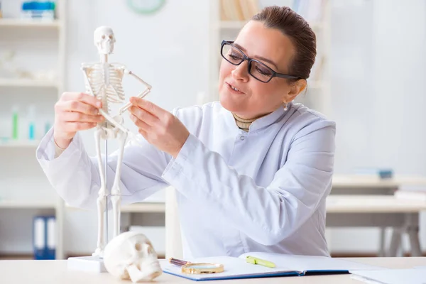 Mulher médico estudando esqueleto humano — Fotografia de Stock