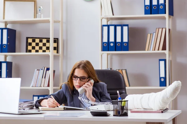 Angestellte mit gebrochenem Bein im Büro — Stockfoto