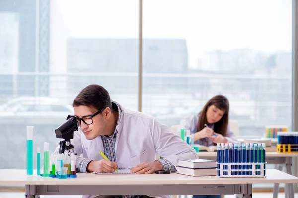 Dois químicos que trabalham em laboratório experimentando — Fotografia de Stock