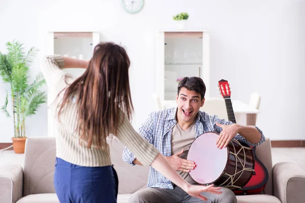 Família jovem cantando e tocando música em casa — Fotografia de Stock