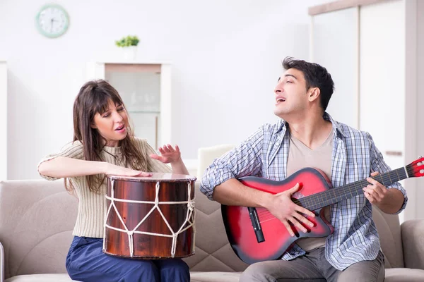 Ung familj sjunger och spelar musik hemma — Stockfoto