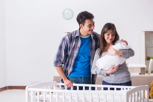 Junge Eltern mit ihrem Neugeborenen in der Nähe des Kinderbettes — Stockfoto