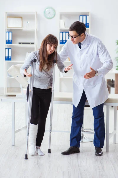 Médico examinando paciente com perna quebrada — Fotografia de Stock