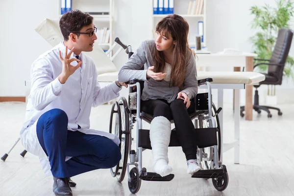 Άνδρας γιατρός που εξετάζει γυναίκα ασθενή σε αναπηρική καρέκλα — Φωτογραφία Αρχείου