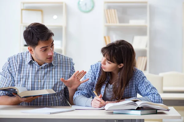 Estudiantes sentados y estudiando en la universidad — Foto de Stock