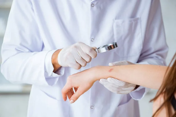 Médico examinando la piel de una paciente femenina — Foto de Stock