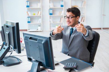 Birçok ekranın önünde oturan bir iş adamı