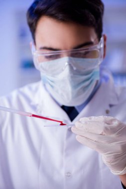 Laboratuvar asistanı hastanede kan örneklerini test ediyor.
