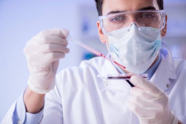 Laboratuvar asistanı hastanede kan örneklerini test ediyor.