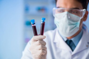 Laboratuvar asistanı hastanede kan örneklerini test ediyor.