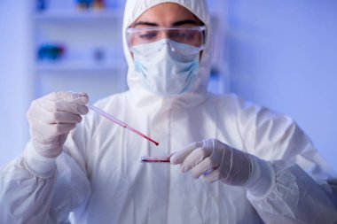 Laboratuvar asistanı hastanede kan örneklerini test ediyor.