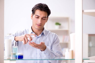 Adam banyoda çalışmak için giyiniyor.