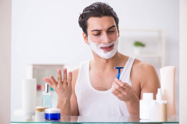 Genç yakışıklı adam sabah erkenden tıraş oluyor.