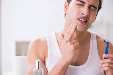 Genç yakışıklı adam sabah erkenden tıraş oluyor.