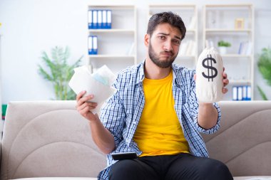 Ödeme yapması gereken faturalara kızgın bir adam.