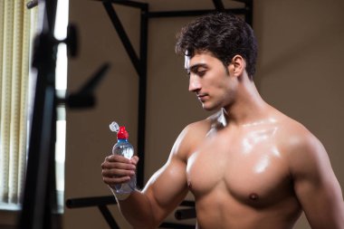 Spor salonunda su içen susamış bir adam.