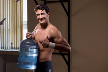 Büyük su şişeli kaslı adam.