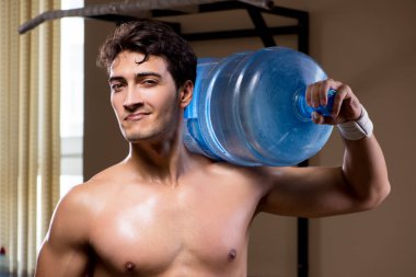 Büyük su şişeli kaslı adam.