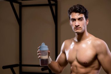 Spor salonunda besin takviyesi olan bir adam.