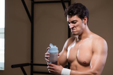 Spor salonunda besin takviyesi olan bir adam.