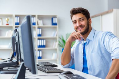 Birçok ekranın önünde oturan bir iş adamı