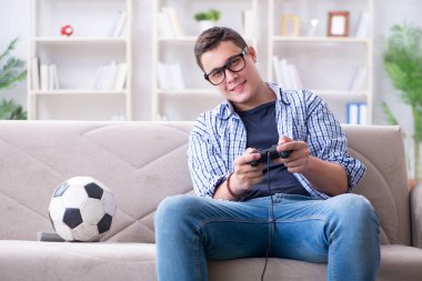 Genç adam evde bilgisayar oyunu oynuyor.