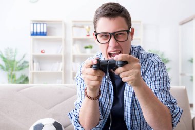 Genç adam evde bilgisayar oyunu oynuyor.