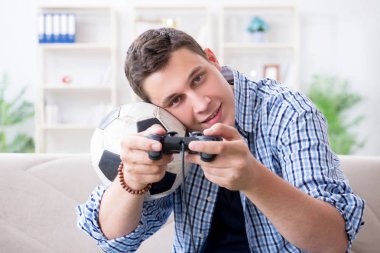 Genç adam evde bilgisayar oyunu oynuyor.
