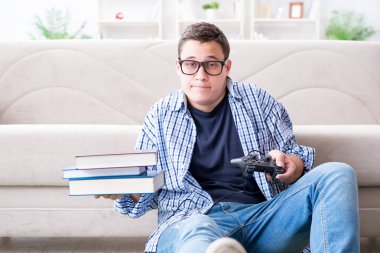 Çalışmayı ve oyun oynamayı dengelemeye çalışan genç öğrenci