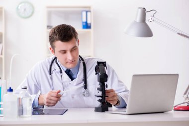 Hastanedeki laboratuvar sonuçlarına bakan erkek doktor.