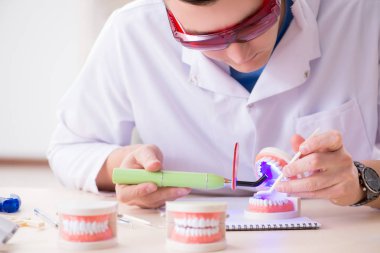 Tıp laboratuarına diş implantı yerleştiren dişçi.