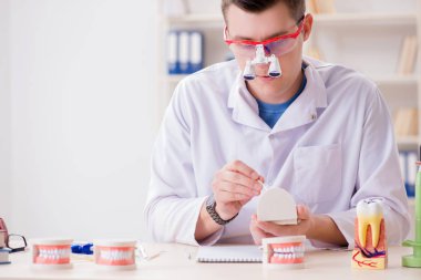 Tıp laboratuarına diş implantı yerleştiren dişçi.