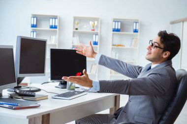 Birçok ekranın önünde oturan bir iş adamı