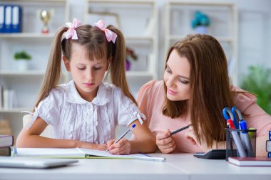 Anne, kızına ödevlerinde yardım ediyor.