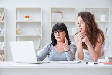 Kızı anneme bilgisayarın nasıl kullanılacağını anlatıyor.