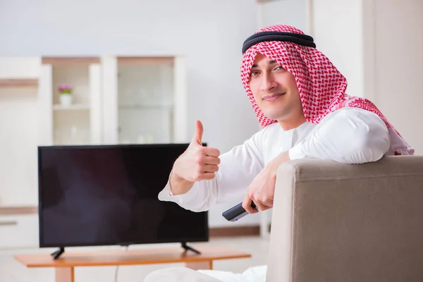 Арабський бізнесмен дивиться телевізор удома. — стокове фото