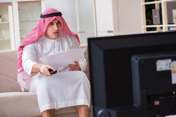 Arab businessman watching tv at home