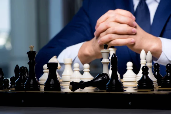 Businessman playing chess in strategy concept — Stock Photo, Image