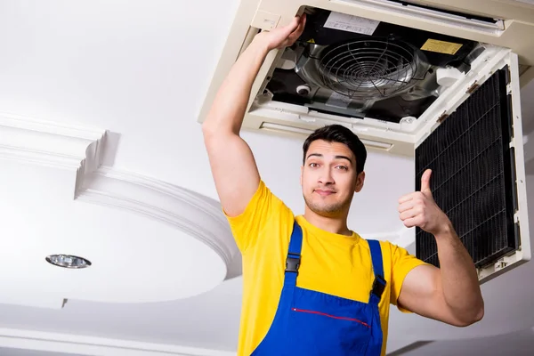 Repairman repairing ceiling air conditioning unit — Stock Photo, Image